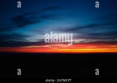 Schöner dramatischer Himmel mit Wolken bei Sonnenuntergang. Natürlicher Sonnenaufgang über der Stadt. Stockfoto