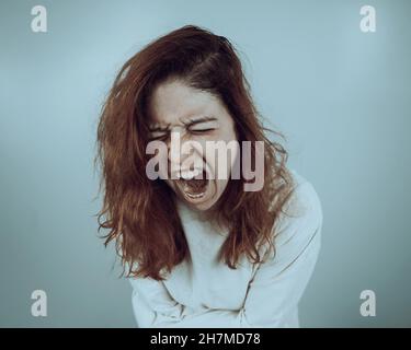 Nahaufnahme Porträt einer verrückten Frau in Zwangsjacke auf weißem Hintergrund. Stockfoto