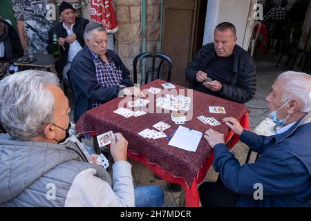Ältere jüdische Männer spielen Karten auf dem Mahane- oder Machane Yehuda-Markt, der oft als „der Schuk“ bezeichnet wird, einem Open-Air-Markt in West-Jerusalem, Israel Stockfoto