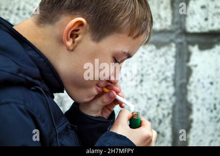 Ein Teenager raucht heimlich die Zigarette auf der Straße Stockfoto