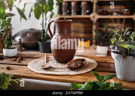 Krug mit heißem Bio-Kakao für die Zeremonie, Nahaufnahme. Gesundes Getränk aus rohen Kakaobohnen im grünen vegetarischen Café Copy space, Ritual für Harmonie in grün Stockfoto