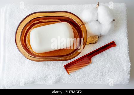 Bad-Accessoires mit Seife, weißem Handtuch, Kamm, Draufsicht. Stockfoto