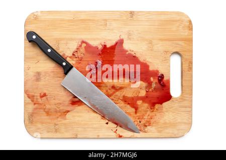 Schneidebrett mit blutiger Oberfläche und Messer isoliert auf weiß. Draufsicht Stockfoto