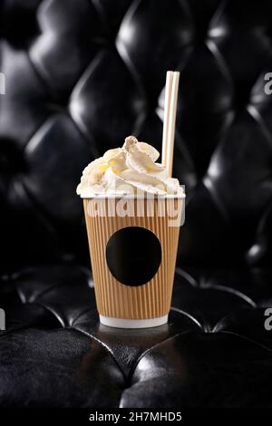 Kaffee mit Schlagsahne in einer Tasse zum Mitnehmen. Platz für das Logo. Ein leckeres Gericht.kulinarische Fotografie. Vorschlag, das Gericht zu servieren. Stockfoto