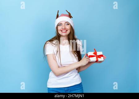 Dies ist für Sie Santa Helfer geben Geschenk-Konzept. Foto von ziemlich lustig funky fröhlich positiv aufgeregt Mädchen mit einem toothy Lächeln hält eine Geschenkbox auf einem hellen blauen Hintergrund Stockfoto