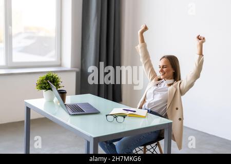 Aufgeregt Geschäftsfrau Erfolge feiern oben im Büro suchen Stockfoto