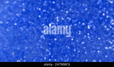 Blau Weiß, Silber, weihnachtlicher Hintergrund mit defokussertem Licht. Hintergrund für das neue Jahr. Weiße oder silberne Lichter auf blauem Hintergrund. Stockfoto