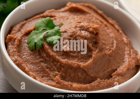 Schüssel mit mexikanisch braun gebratenen Bohnen Paste aus nächster Nähe Stockfoto