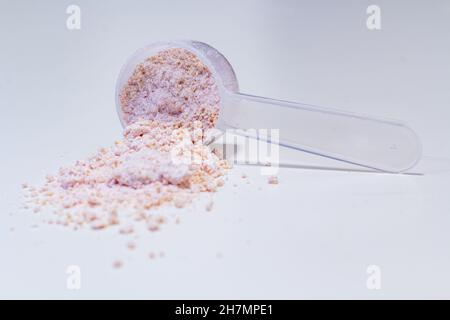 Plastiklöffel mit rotem Pulver Stockfoto
