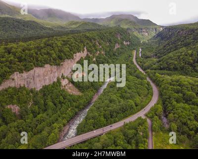 Sounkyo im Daisetsuzan National Park ist eine malerische Schlucht, die von 100m hohen bewaldeten Klippen umgeben ist, durch die ein Fluss fließt und eine Straße führt. Stockfoto