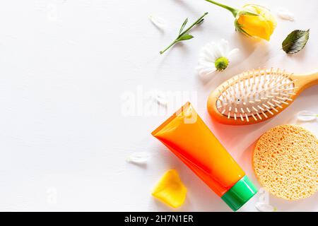 Beauty-Produkte Kosmetik, Kamm und Blumen auf weißem Hintergrund mit Platz für Text Stockfoto