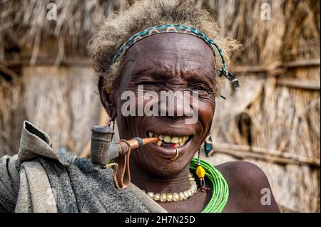 Alte Frau des Jiye-Stammes, die eine Pfeife raucht, Eastern Equatoria State, Südsudan Stockfoto