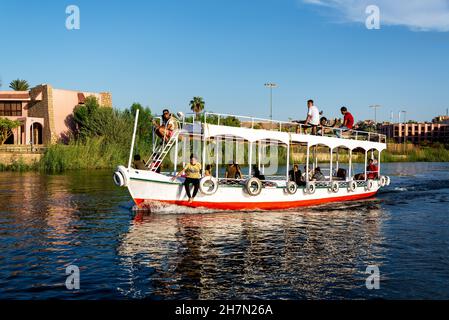 ASSUAN, ÄGYPTEN - 30. JULI 2021: Schiff voller Passagiere auf dem Nil in Assuan, Ägypten, am 30. Juli 2021 Stockfoto