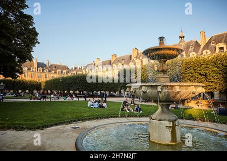 Abendstimmung mit Brunnen vor mittelalterlichen Fassaden. Blick auf das Zentrum von Place des Vosges, Marais, 3rd und 4th Arrondissement, Paris Stockfoto