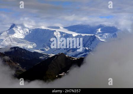 Schneebedeckte Berge und Gletscher, Wolken, Luftaufnahme, Wrangell-St. Elias National Park, Alaska, USA Stockfoto