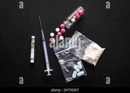 Geld und Drogen auf schwarzem Hintergrund Stockfoto
