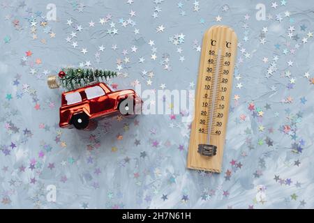 Thermometer zeigt niedrige Temperatur und Weihnachtsdekoration auf weiß mit Sternen festlichen Hintergrund. Winter- und Urlaubswetterkonzept, Platz kopieren Stockfoto
