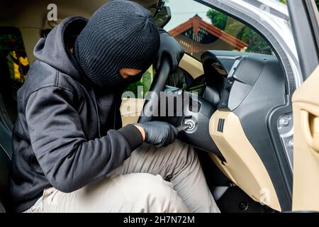 Autodieb Mann versucht, das Auto auf der Straße zu stehlen Stockfoto