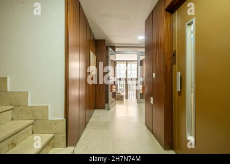 Metallaufzugstür im Portal eines Gebäudes mit Böden aus cremefarbenem Marmor Stockfoto