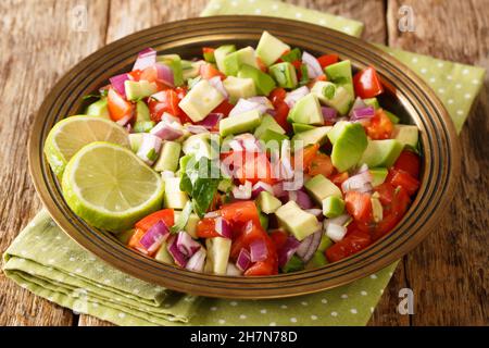 Kachumbari ist ein ostafrikanischer frischer Salat auf Tomaten- und Zwiebelbasis, der perfekt als Vorspeise für Hauptmahlzeiten in der Nähe auf dem Teller auf dem Tisch geeignet ist. H Stockfoto