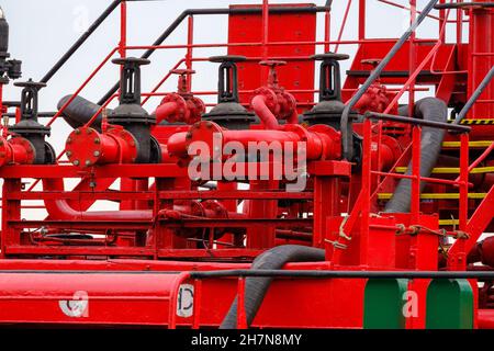 Rote Rohre vor dem Industrieschiff Stockfoto