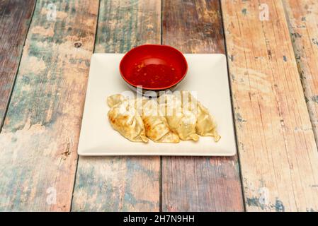 Portion Gyozas gefüllt mit würzigem Schweinefleisch gebraten mit Sauce zum Eintauchen Stockfoto