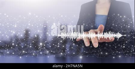 Konzept der Musik mit Ihnen, Software für die Aufnahme verwendet. Hologramm-Zeichen auf dem digitalen Bildschirm mit Handberührung auf dem hellen, unscharfen Hintergrund der Stadt. Audiobook Audio Tech Stockfoto