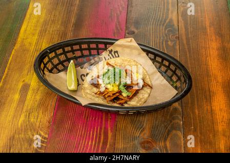 taco al Pastor mit Eintopf von Fleisch, Zwiebeln, Mango, Limette und Koriander Stockfoto