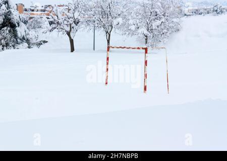 Schneebedeckter Fußballplatz, von dem nur das Tor zu sehen ist, Winterbeginn, großer Schneefall. Stockfoto