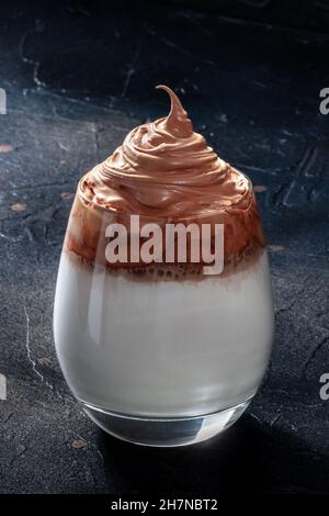 Dalgona kalter Kaffee. Trendiges koreanisches Getränk mit Instantkaffee und Creme auf schwarzem Hintergrund Stockfoto