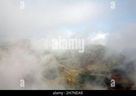 Nebel wirbelt um den Gipfel von Wetherlam vom Gipfel des alten Mannes von Coniston in der Nähe von Coniston, dem Lake District Cumbria England aus gesehen Stockfoto