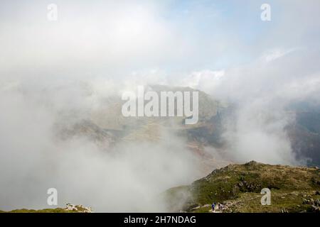 Nebel wirbelt um den Gipfel von Wetherlam vom Gipfel des alten Mannes von Coniston in der Nähe von Coniston, dem Lake District Cumbria England aus gesehen Stockfoto