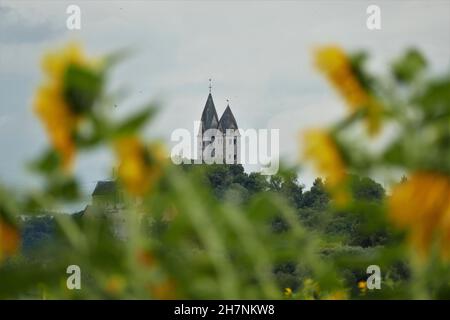 Türme Aus Der St.-Lubentius-Kirche Mit Gelben Sonnenblumen In Dietkirchen / Lahntal Stockfoto