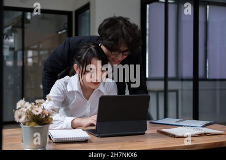 Asiatische Studenten der Universität lernen Sprache mit digitalem Tablet und Internet, arbeiten gemeinsam an einem Projekt. Prüfungsvorbereitung. Online-Bildungskonzept Stockfoto