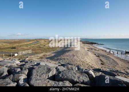 Verlassene Verteidigung des Meeres, Erosion, Steingroynes, Kieselsteine und Steine, die das Meer und RSPB Medmerry Naturschutzgebiet trennen. Blick südöstlich Richtung Selsey, Stockfoto