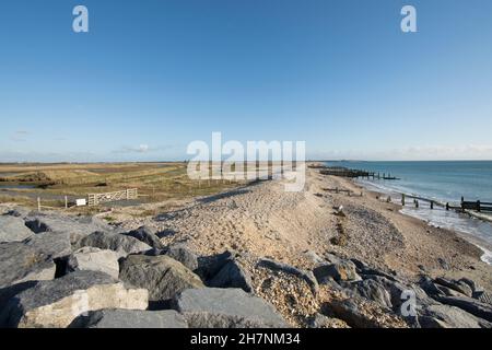 Verlassene Verteidigung des Meeres, Erosion, Steingroynes, Kieselsteine und Steine, die das Meer und RSPB Medmerry Naturschutzgebiet trennen. Blick südöstlich Richtung Selsey, Stockfoto