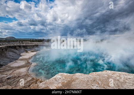 Sturmwolken, Dampf steigt vom Excelsior Geyser Crater, jetzt heißer Frühling, Midway Geyser Basin, Yellowstone National Park, Wyoming, USA Stockfoto