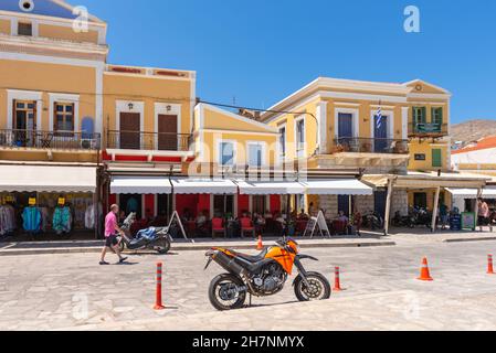 SYMI, GRIECHENLAND - 15. Mai 2018: Die Strandpromenade im Hafen von Symi Stockfoto