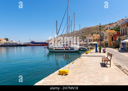 SYMI, GRIECHENLAND - 15. Mai 2018: Die Strandpromenade im Hafen von Symi Stockfoto