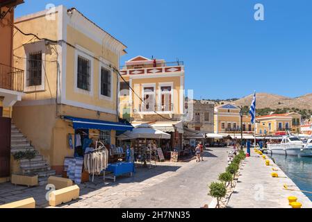 SYMI, GRIECHENLAND - 15. Mai 2018: Die Strandpromenade im Hafen von Symi Stockfoto