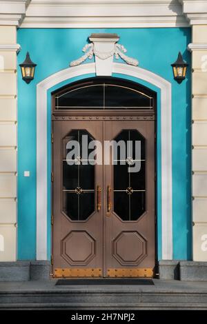 Elegante braune Eingangstür an der blauen Wand Stockfoto