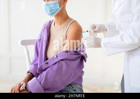 Antivirale Immunisierung. Krankenschwester, die eine Injektion mit Coronavirus-Impfstoff anstellt und eine Frau zum Covid-19-Schutz injiziert Stockfoto