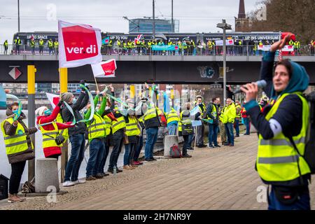 Bremen, Deutschland. 24th. November 2021. An der Weserpromenade zwischen Bürgermeister-Smidt-Brücke und Wilhelm-Kaisen-Brücke demonstrieren die Beschäftigten des öffentlichen Dienstes mit einer Menschenkette. Im anhaltenden Tarifkonflikt für die Beschäftigten der Bundesländer setzt die Gewerkschaft Verdi ihre Warnstreiks fort. Verdi und der Beamtenverband dbb fordern bundesweit fünf Prozent mehr Lohn für die mehr als eine Million Staatsangestellte, mindestens aber 150 Euro mehr pro Monat und sogar 300 Euro mehr im Gesundheitswesen. Quelle: Sina Schuldt/dpa/Alamy Live News Stockfoto