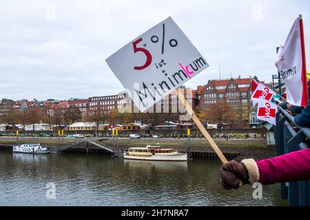 Bremen, Deutschland. 24th. November 2021. An der Weserpromenade zwischen Bürgermeister-Smidt-Brücke und Wilhelm-Kaisen-Brücke demonstrieren die Beschäftigten des öffentlichen Dienstes mit einer Menschenkette. Im anhaltenden Tarifkonflikt für die Beschäftigten der Bundesländer setzt die Gewerkschaft Verdi ihre Warnstreiks fort. Verdi und der Beamtenverband dbb fordern bundesweit fünf Prozent mehr Lohn für die mehr als eine Million Staatsangestellte, mindestens aber 150 Euro mehr pro Monat und sogar 300 Euro mehr im Gesundheitswesen. Quelle: Sina Schuldt/dpa/Alamy Live News Stockfoto