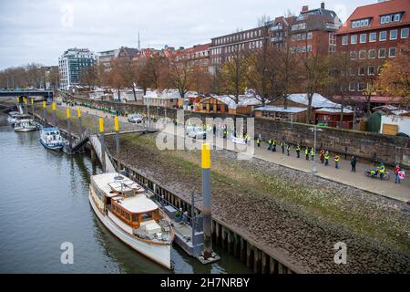 Bremen, Deutschland. 24th. November 2021. An der Weserpromenade zwischen Bürgermeister-Smidt-Brücke und Wilhelm-Kaisen-Brücke demonstrieren die Beschäftigten des öffentlichen Dienstes mit einer Menschenkette. Im anhaltenden Tarifkonflikt für die Beschäftigten der Bundesländer setzt die Gewerkschaft Verdi ihre Warnstreiks fort. Verdi und der Beamtenverband dbb fordern bundesweit fünf Prozent mehr Lohn für die mehr als eine Million Staatsangestellte, mindestens aber 150 Euro pro Monat und sogar 300 Euro mehr im Gesundheitswesen. Quelle: Sina Schuldt/dpa/Alamy Live News Stockfoto