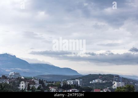 Aluschta, Russland, 13. August 2016 - Blick auf Häuser und Bäume auf Bergen in Wolken Stockfoto