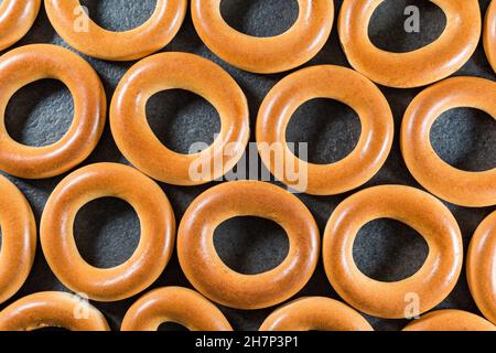 Ukrainische, russische und weißrussische traditionelle Backwaren frisch leckere Brotringe (Bagels, Sushki oder Baranki), isoliert auf dunklem Hintergrund. Stockfoto