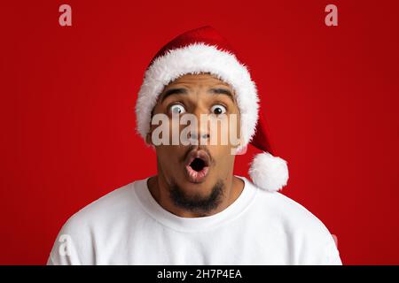 Nahaufnahme eines schockierten afroamerikanischen Mannes in santa hat Stockfoto