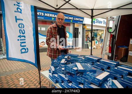 Chesham, Buckinghamshire, Großbritannien. 24th. November 2021. Ein Einkäufer holt sich kostenlose Covid-19-Testkits. Am heutigen Markttag wurden vom Buckinghamshire Council kostenlose Covid-19-Lateral-Flow-Tests an Käufer in Chesham vergeben. Die Regierung fordert die Käufer auf, vor dem Weihnachtseinkauf einen lateralen Covid-19-Flow-Test durchzuführen, um zu versuchen, die steigende Zahl positiver Covid-19-Fälle zu senken. Quelle: Maureen McLean/Alamy Live News Stockfoto