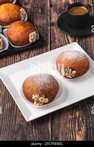 Bombolon oder Bomboloni ist ein italienisches gefülltes Donut- und Snackfutter. Deutsche Krapfen - Krapfen oder berliner - gefüllt mit Marmelade und Schokolade Stockfoto